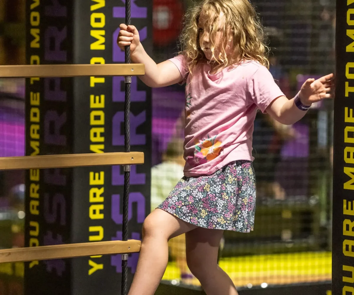 A little girl playing in a ninja themed play area