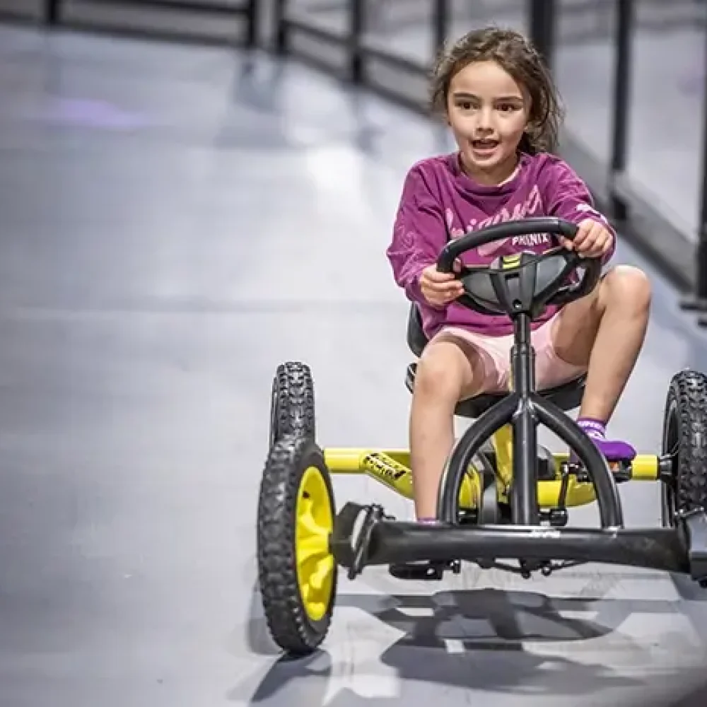 A young girl enjoys the thrills of the kids Pedal Car Track at SuperPark