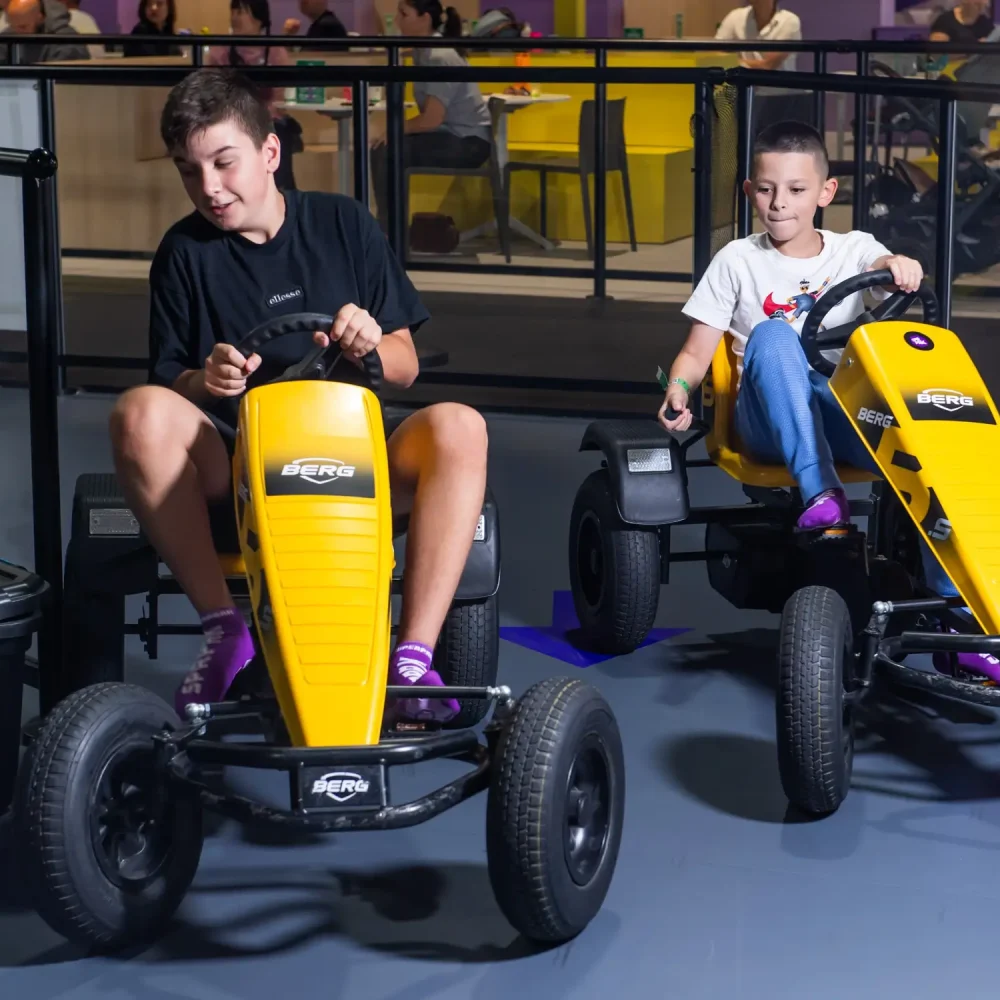 Two young boys ride the Pedal Car Track one of the best school holiday activities