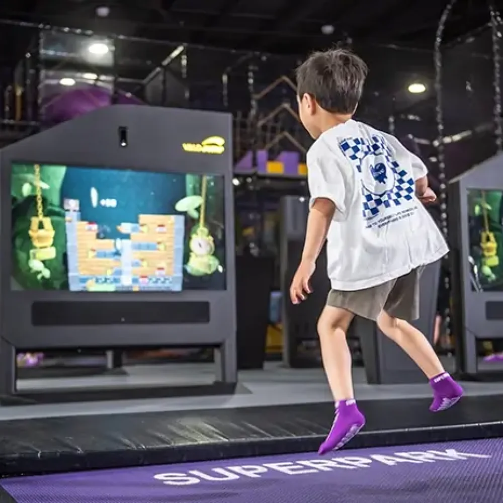 Young boy jumps on the interactive SuperJump trampolines