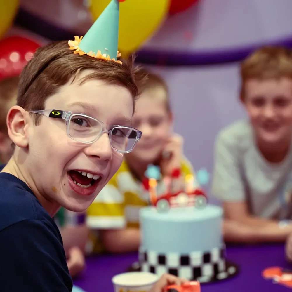 Young boy wears a birthday hat at a kids party venue