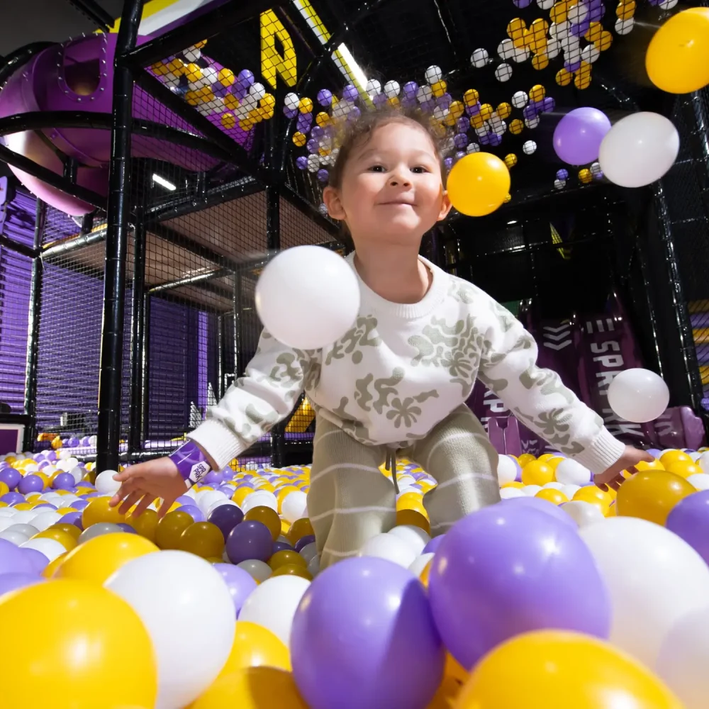 Young girl plays in the ball pit at SuperPark